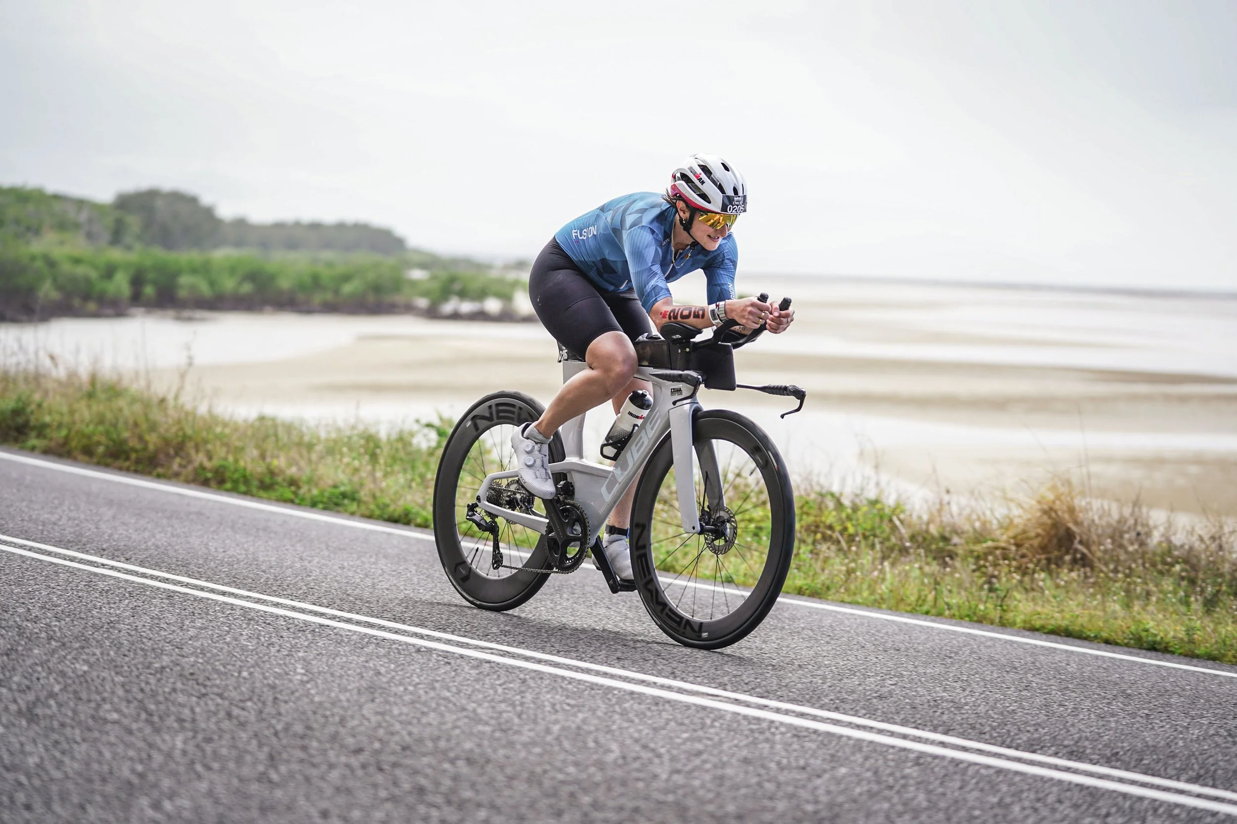 Emilie on a time trial bike along a coastal road
