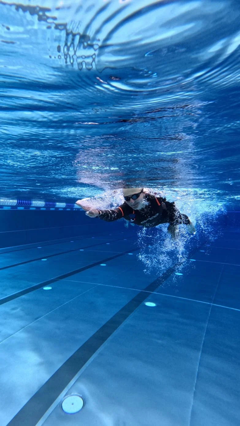 Emilie swimming in a pool, seen from underwater